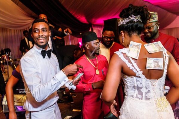 Putsammy spraying his bride with money at their wedding party