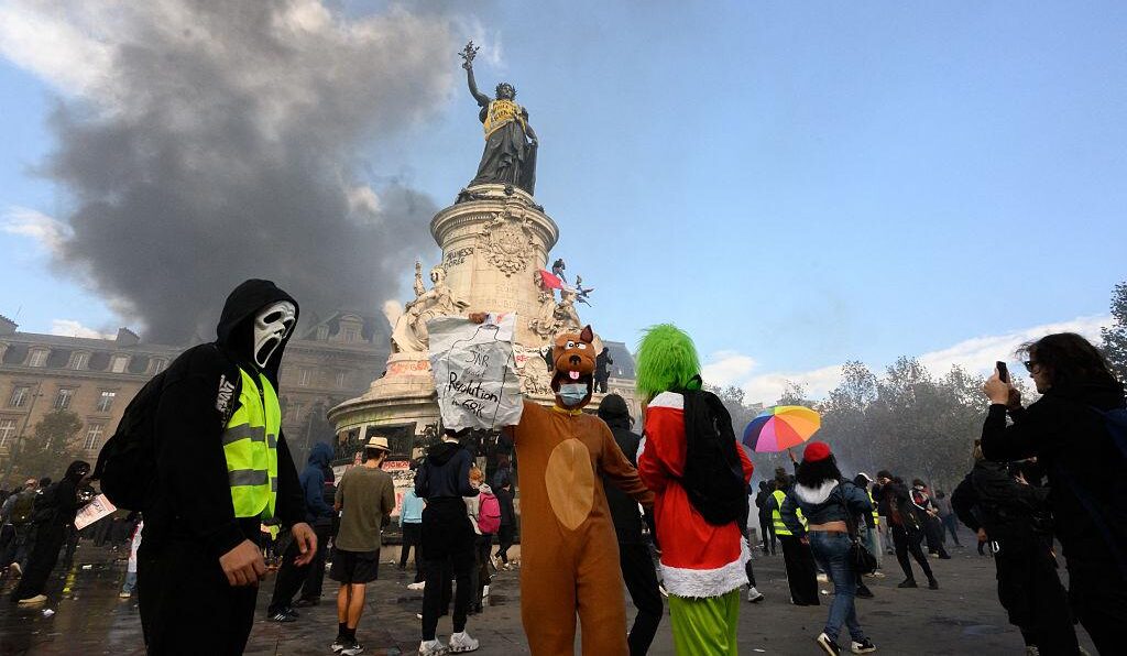 Protesters wearing Halloween masks and costumes