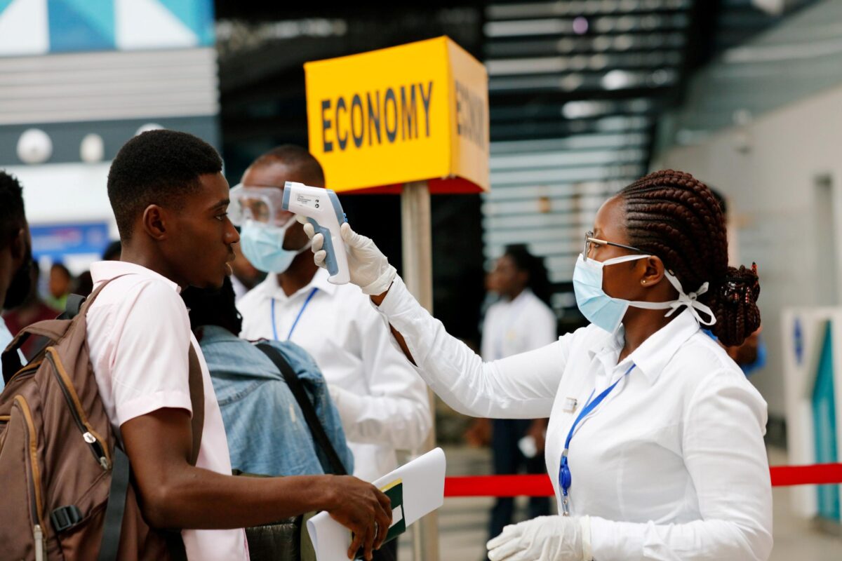 Flight officer checking passenger’s temperature