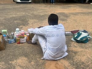 Arrested suspect sits on the floor with unlicensed medical supplies
