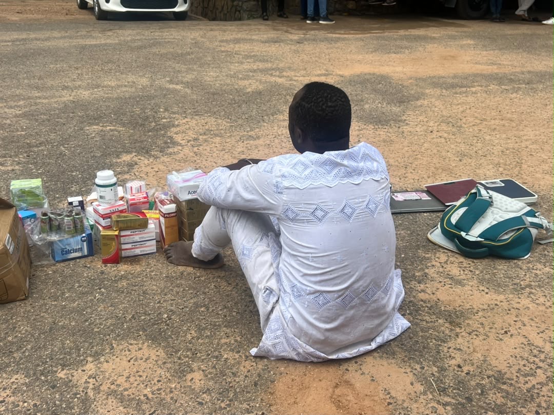 Arrested suspect sits on the floor with unlicensed medical supplies