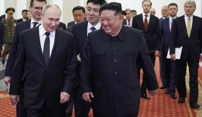 Kim standing with Putin