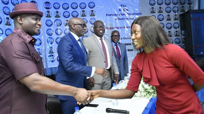 NDDC-Managing Director Dr Samuel Ogbuku congratulating the best performing scholarship student Miss-Omogbemi Olayemi at a-pre-departure and award ceremony in PortHarcourt
