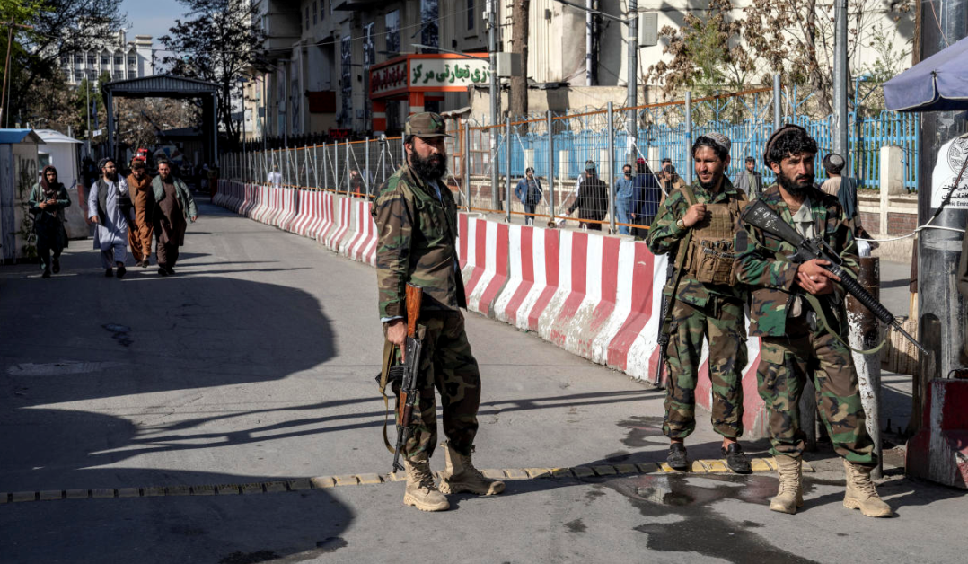 Taliban fighters stand guard at the scene of a deadly explosion near the Foreign Ministry in Kabul