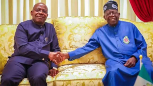 Otti standing with Tinubu