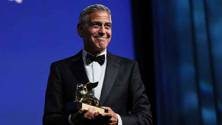Clooney posing with award