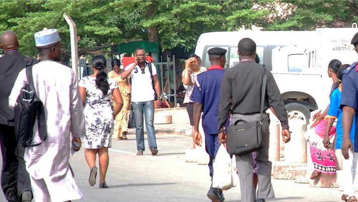 Nigerians walking under a hot sun