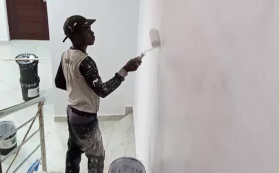 A painter applying paint to the wall