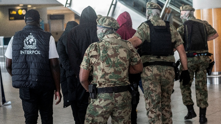 Pictures of the extradited fraudsters with security operatives