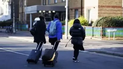 Migrants dragging baggage to UK.