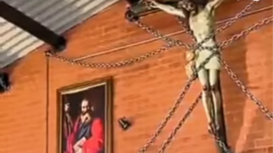 Image of the crucifixion of Jesus secured to a church wall with chains