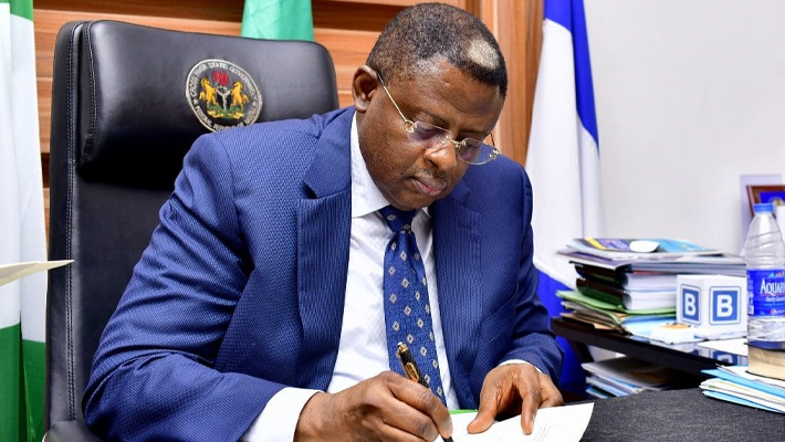 Bassey Otu signing document