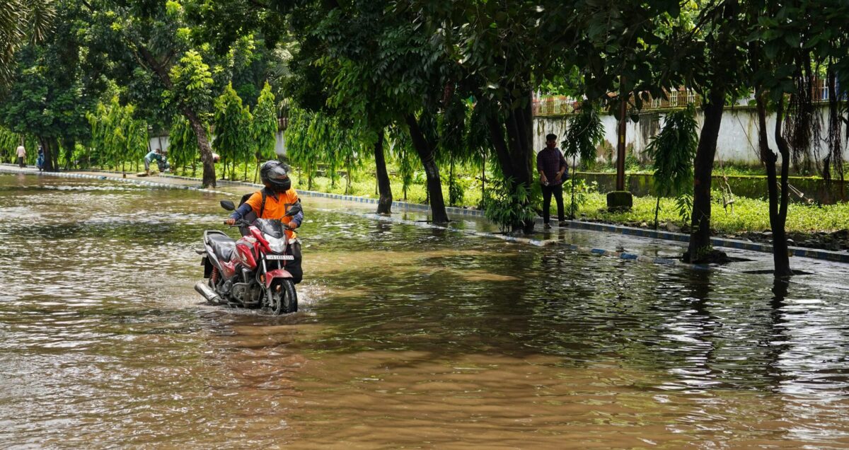 Motorbikes riding through flooded road
