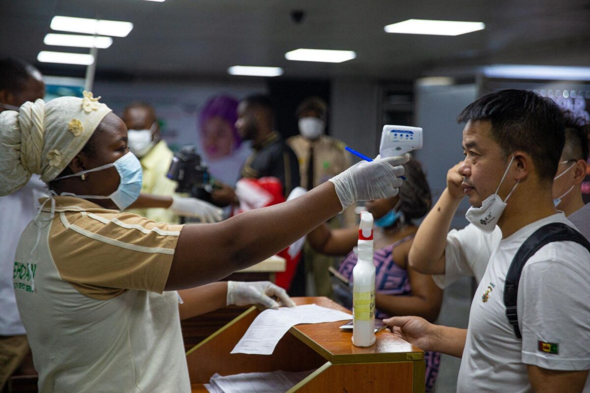 Flight officer checking passenger’s temperature