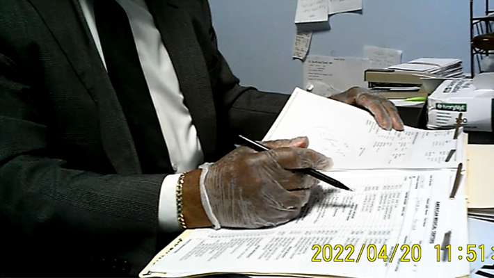 Brown-Arkah in an undercover recording meeting with a confidential source posing as a patient holding a pen over the patient’s billing sheet.