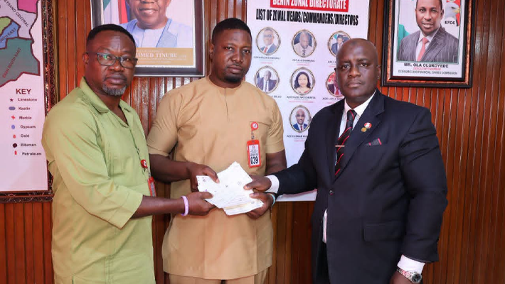 Handing over a draft of recovered N80,000,000 to Ifeanyi Innocent Madueke